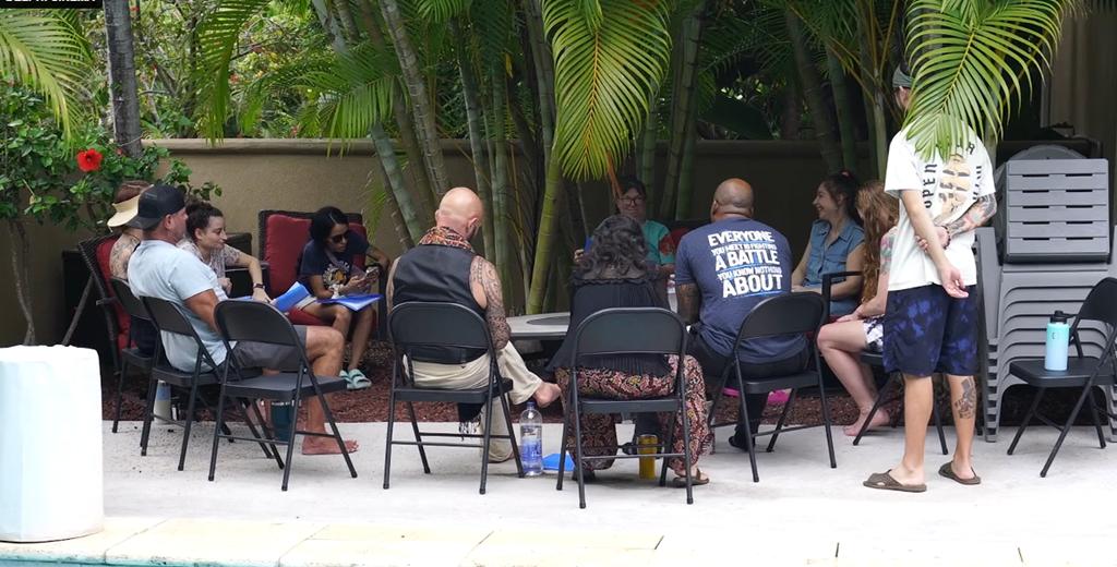 Healing Heroes Hawaii retreat participants in a small group circle, sharing in a tropical Hawaii setting